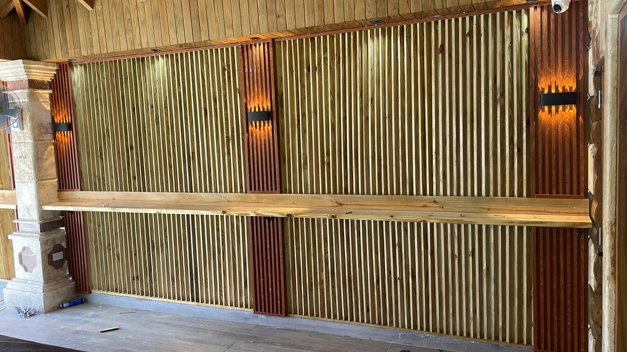 Pared en madera con palos que permiten la ventilacion, luces y paneles incluidos